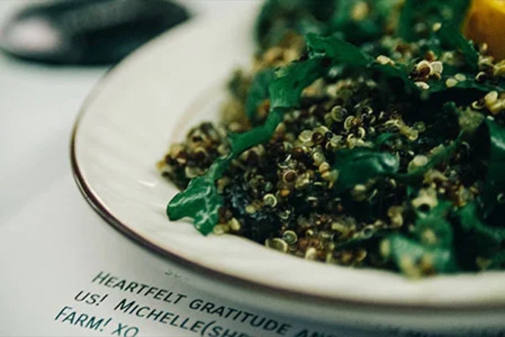 A plated kale salad on a printed harvest dinner menu