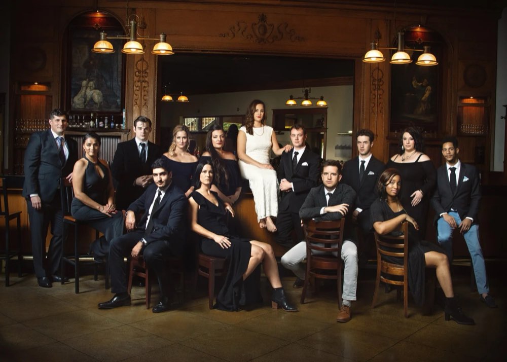 A wedding party in suits and dresses posing at Bell Street