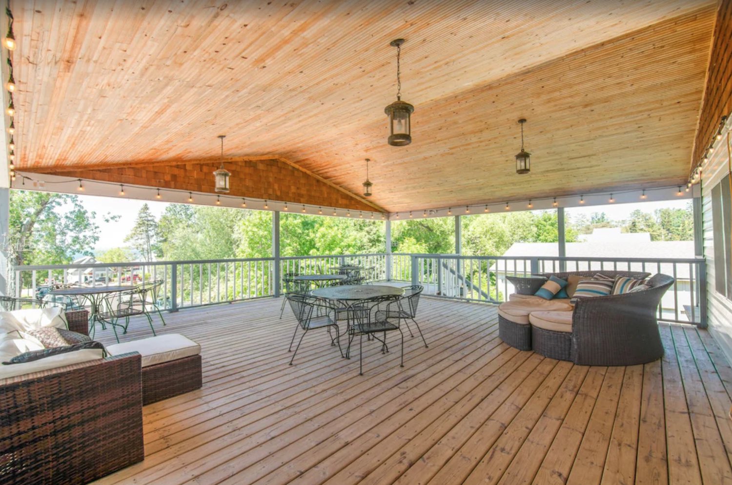 The big covered front deck upstairs with couches and tables
