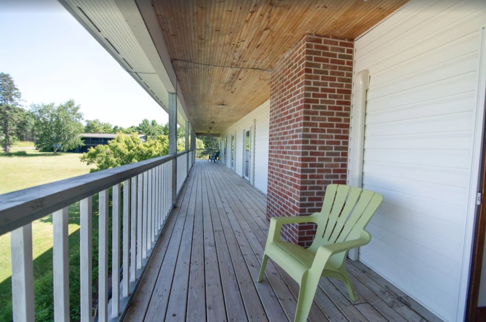 Side porch with a green Adirondack chair