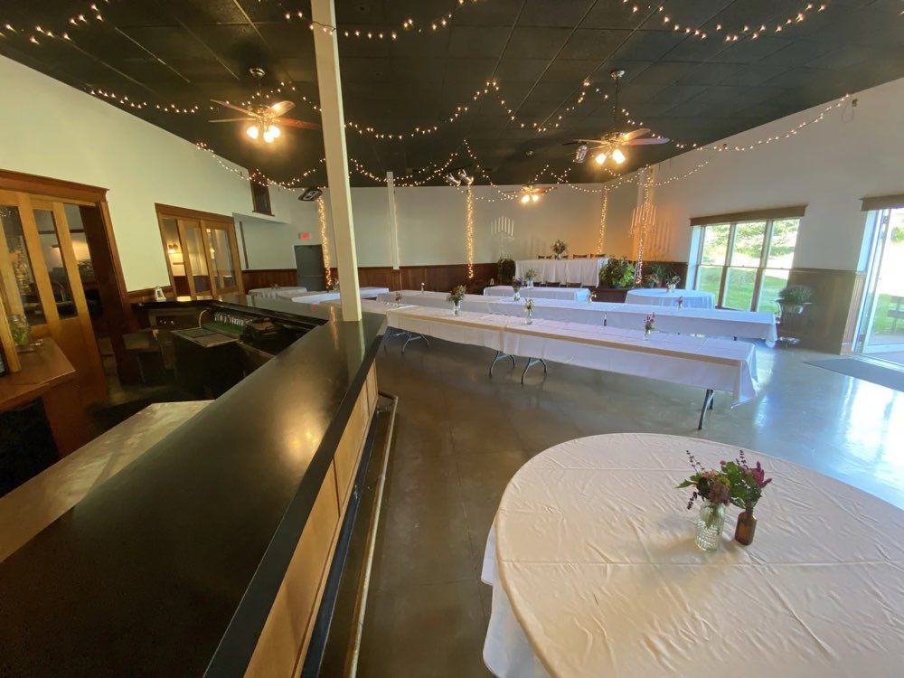 The back bar room set with round tables in front of the stage