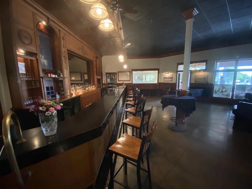 The front bar with stools, a long wooden bar and lounge chairs